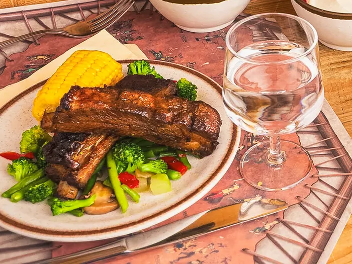 Assiette de travers de porc grillés avec maïs et légumes verts au Crockett’s Tavern