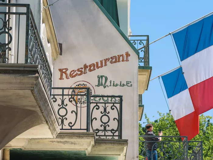 Façade du Restaurant Mille Fleurs avec balcon en fer forgé et drapeau français, à Europa-Park