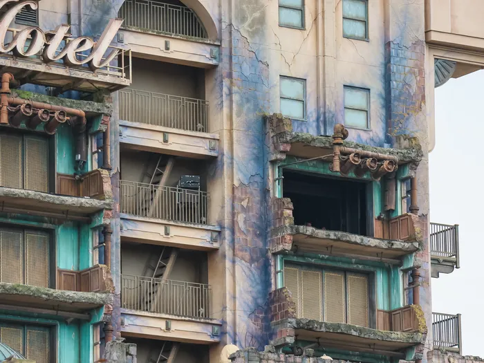 Détail de la façade fissurée de la Tower of Terror avec balcons endommagés et enseigne « Hotel »