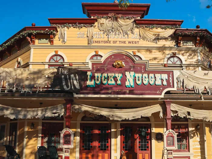 La façade jaune du Lucky Nugget Saloon habillée de toiles pour Halloween (« The UNlucky Nugget »), à Frontierland.