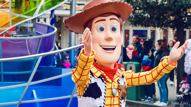 Woody from Toy Story, in his cowboy hat and sheriff’s star, waves to visitors from his Disney Stars on Parade float at Disneyland Paris