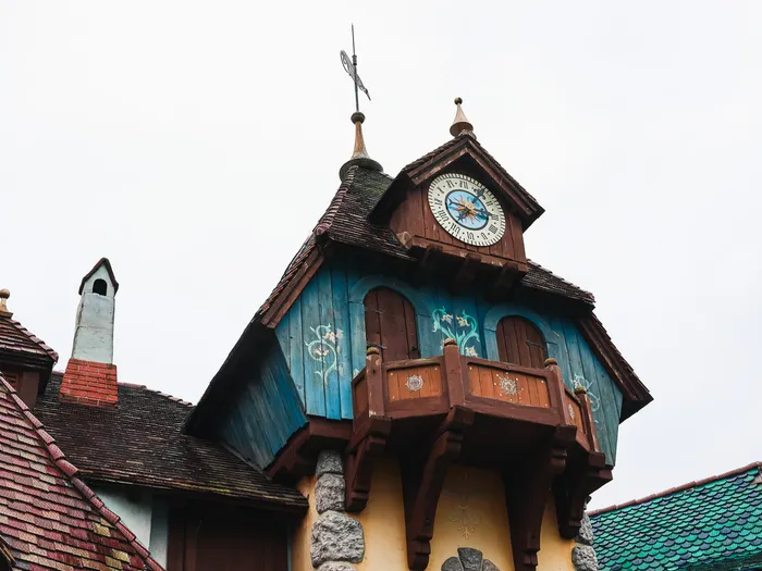 Tourelle à balcon bleu et horloge du restaurant Au Chalet de la Marionnette, dans le décor de Fantasyland.