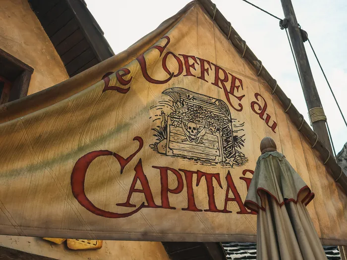 Painted canvas banner for Le Coffre du Capitaine with a treasure chest, on the front of the shop at Disneyland Paris