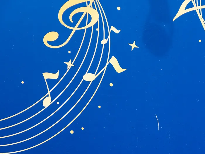 Panneau bleu orné de portées, notes et clé de sol dorées, décor du spectacle Mickey PhilharMagique à Discoveryland.