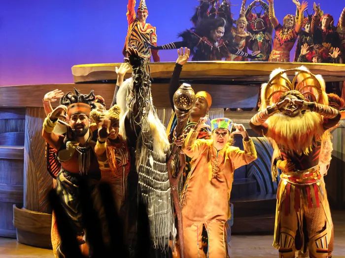 Artistes en costumes africains levant les bras sur scène lors du spectacle Le Roi Lion à Disneyland Paris