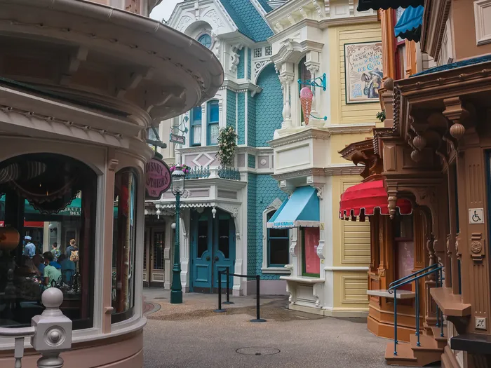 Façades victoriennes pastel et boutique en rotonde le long de Main Street USA, rue déserte au petit matin.
