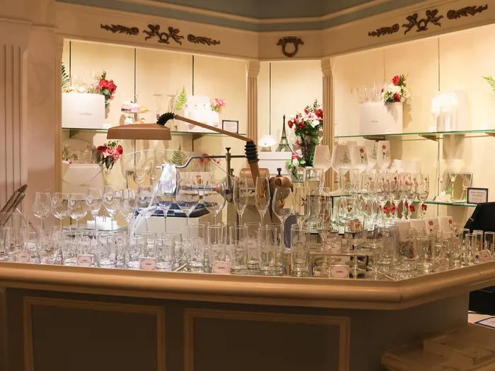 Counter of engraved glassware and rose bouquets at Harrington’s at Disneyland Paris.
