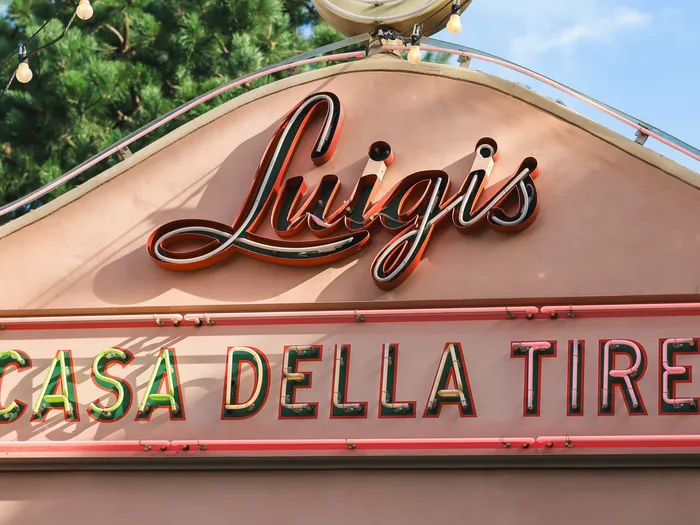 Pink and green neon sign of Luigi’s Casa Della Tires, the Cars tyre shop at Cars Quatre Roues Rallye, Disneyland Paris