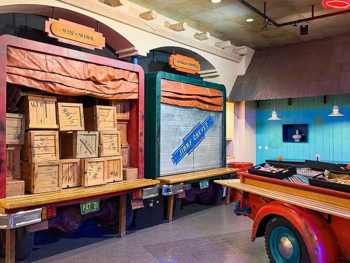 Stations de buffet aménagées en bennes de camions chargées de caisses de vin, décor Route 66 de La Cantina.