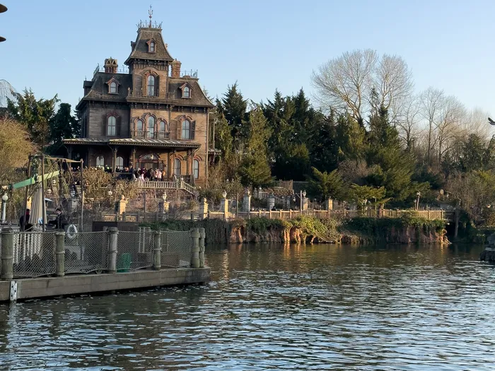 Manoir victorien de Phantom Manor surplombant l’eau à Frontierland par une journée d’hiver ensoleillée