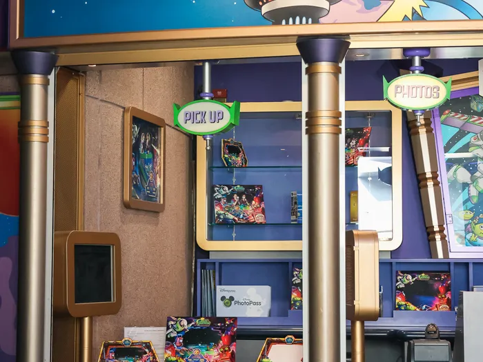 PhotoPass desk at Star Command Photographers, topped by a Toy Story alien holding a camera