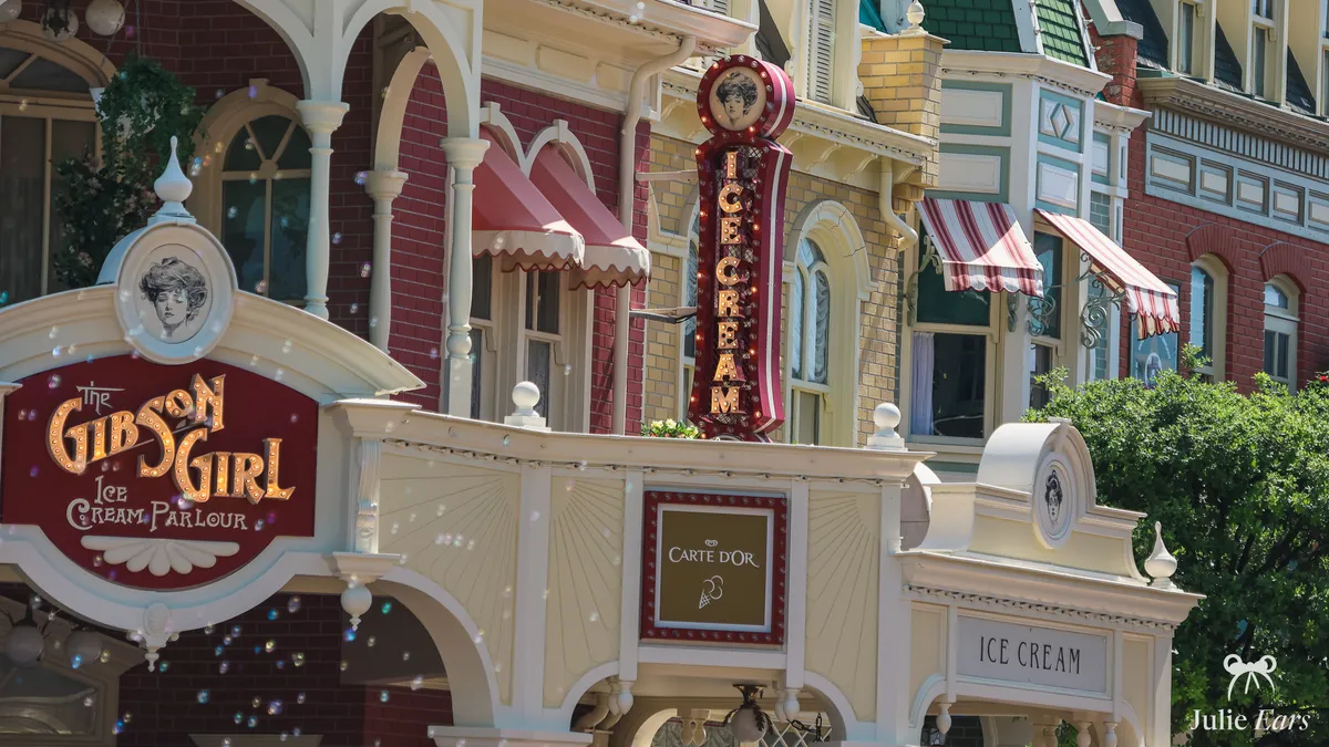 The Gibson Girl Ice Cream Parlour on Main Street U.S.A. at Disneyland Paris, with its tall illuminated "Ice Cream" sign and soap bubbles