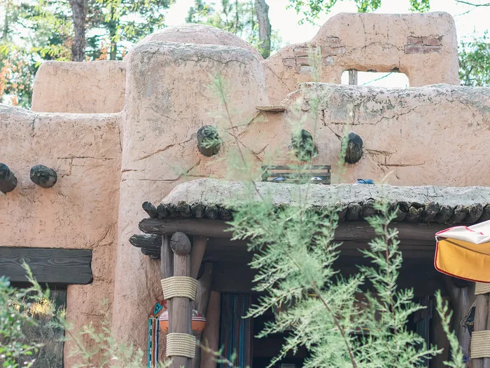 Pueblo Trading Post at Disneyland Paris: a rounded, stepped adobe building like a pueblo village, with jutting beams and log pillars