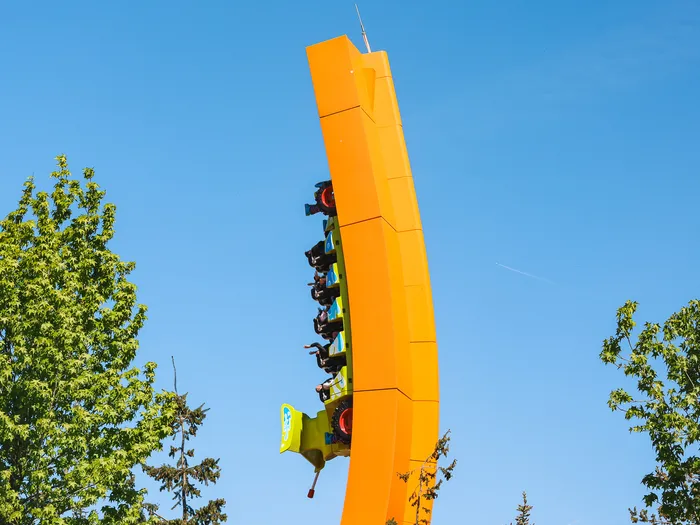 Le wagon vert de RC Racer gravit la rampe orange incurvée face au ciel bleu