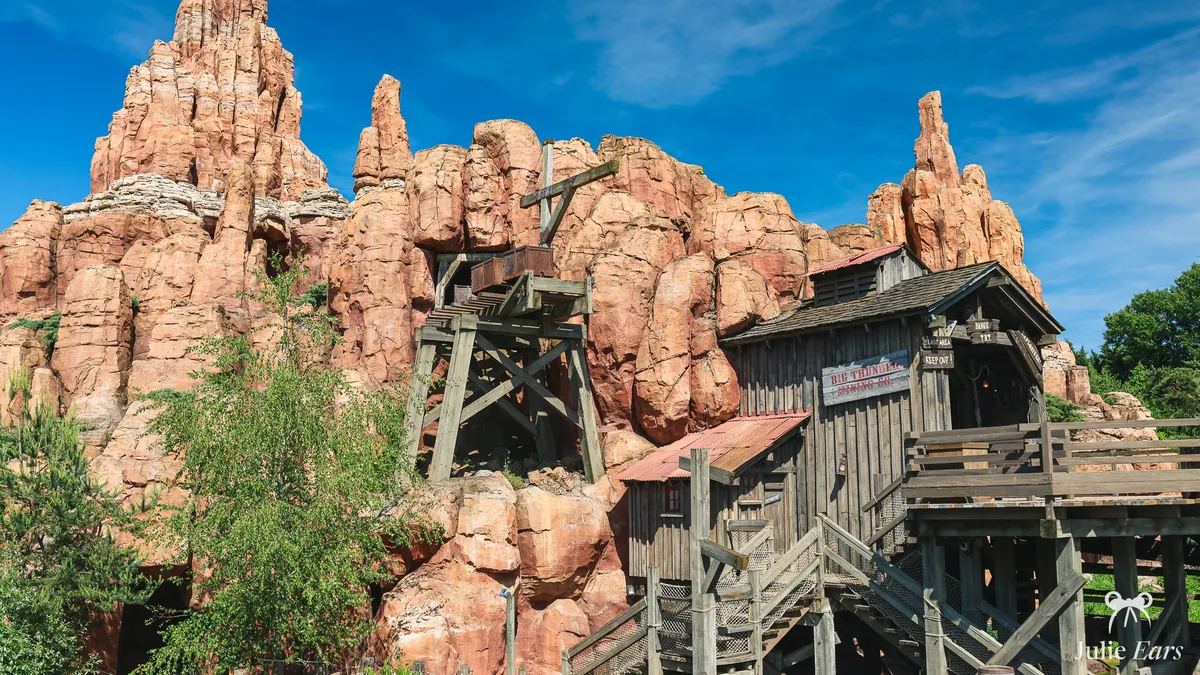 Red rock pinnacles of Big Thunder Mountain in Frontierland, Disneyland Paris, with a wooden mine headframe and the Big Thunder Mining Co. shack