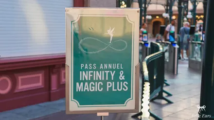 Infinity and Magic Plus annual pass sign marking the entrance reserved for these passes at Disneyland Paris, with the turnstiles behind