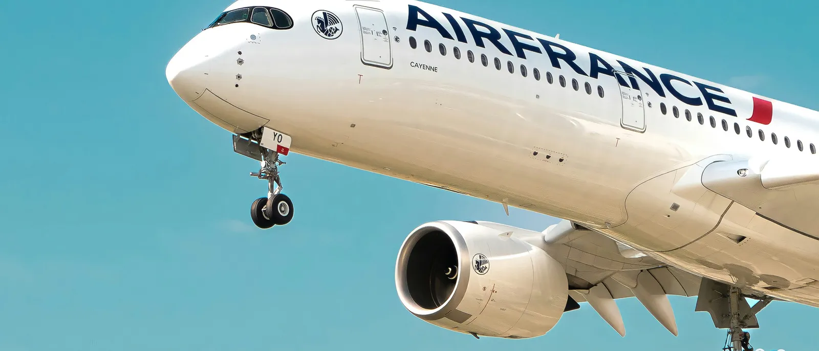 Avion Air France en approche, train d’atterrissage sorti, dans un ciel bleu clair vers un aéroport parisien.