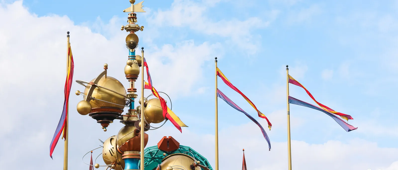 Drapeaux claquant au vent au-dessus des flèches dorées de Discoveryland