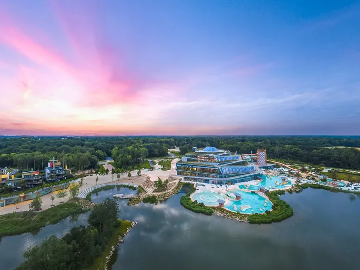 Vue aérienne de Villages Nature Paris au coucher de soleil, avec sa lagune et sa forêt près de Disneyland Paris