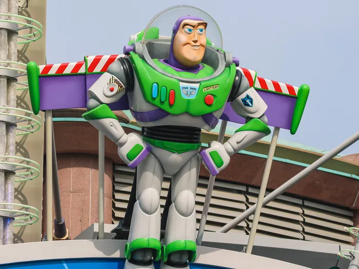 Grande statue de Buzz l’Éclair les poings sur les hanches, au-dessus de l’entrée de l’attraction à Discoveryland.