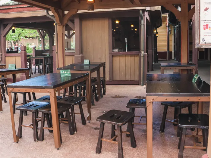 Terrasse couverte du Last Chance Cafe avec tables et tabourets en bois et comptoir de commande.