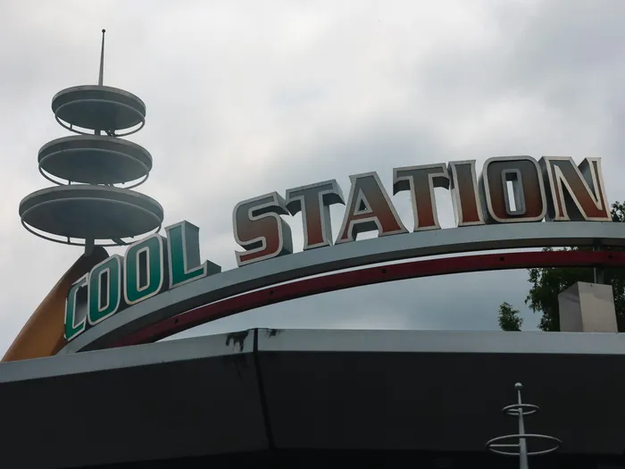 Enseigne « Cool Station » et sa tourelle à soucoupes sous un ciel gris, dans Discoveryland à Disneyland Paris.