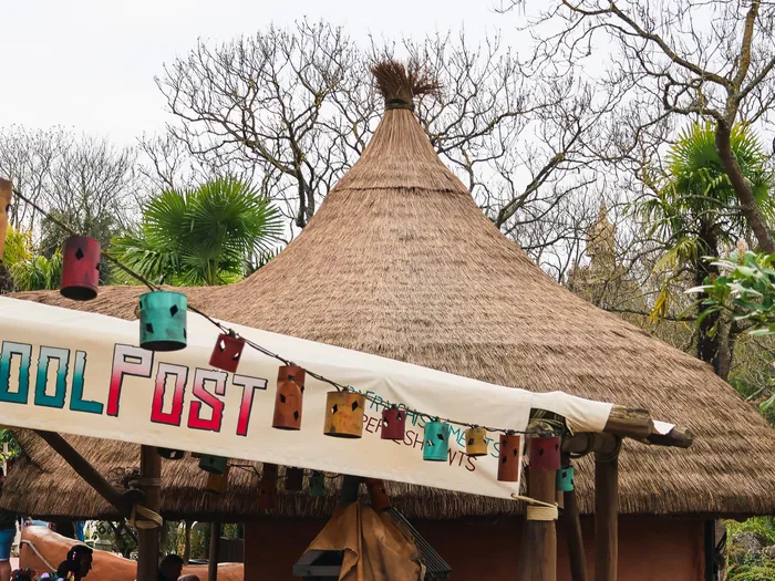 Kiosque Cool Post au toit de chaume avec sa banderole, en extérieur à Adventureland