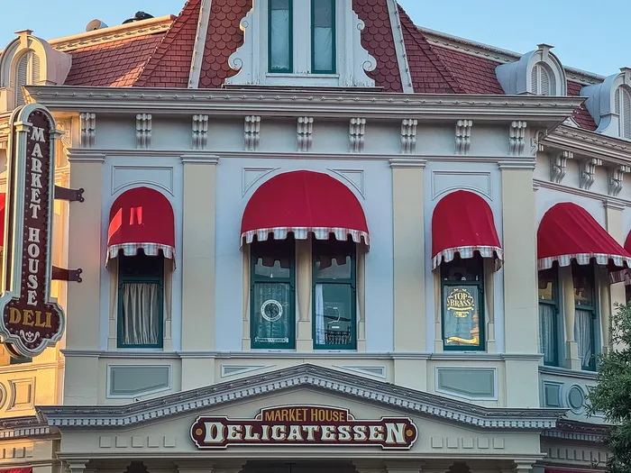 Façade du Market House Delicatessen avec stores rouges et enseigne verticale, Main Street U.S.A.