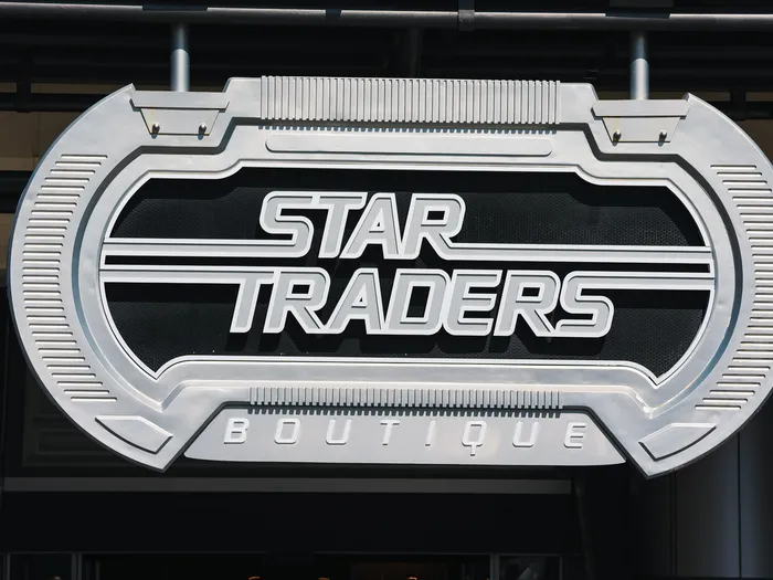 Metal sign of the Star Traders shop at Disneyland Paris, with its spaceport decor