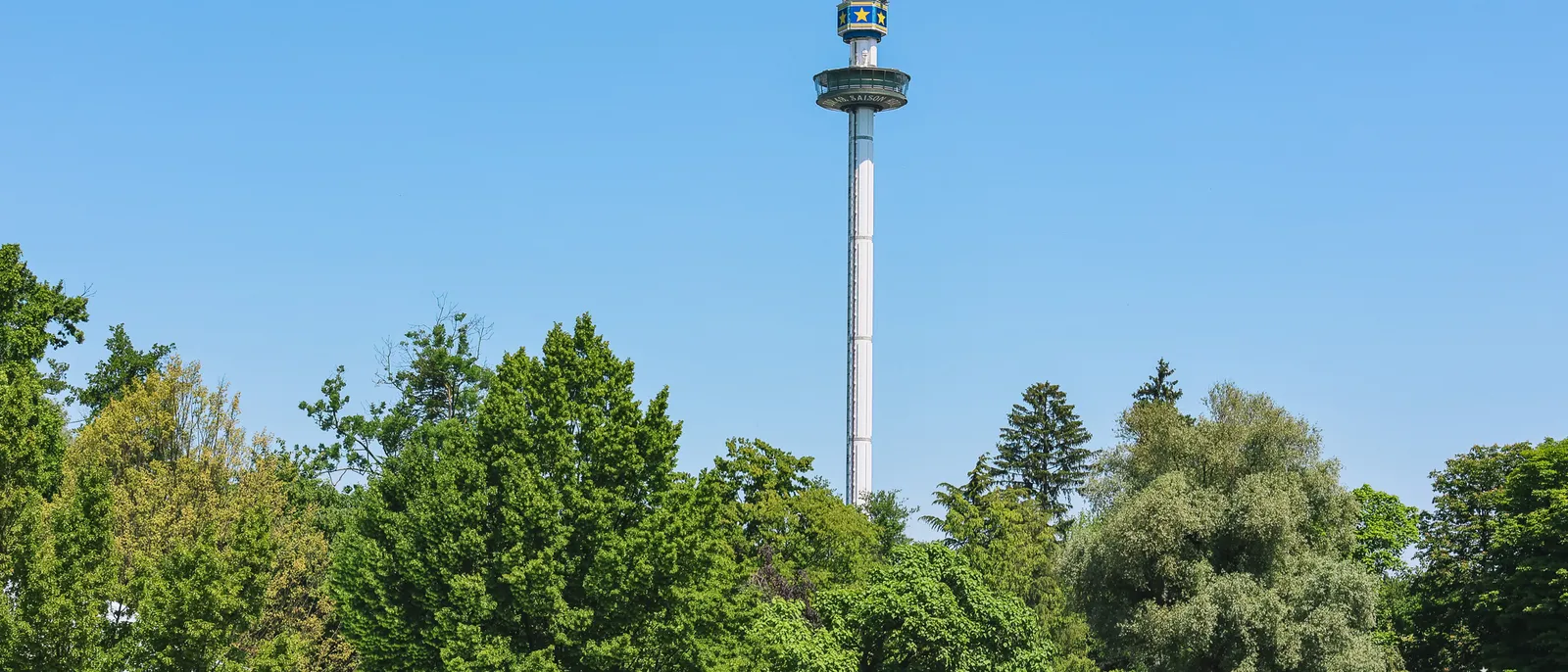 La haute tour panoramique dépasse la cime des arbres sous un ciel bleu à Europa-Park