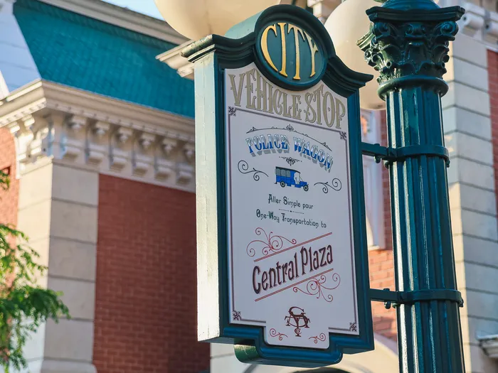 Panneau ancien « City Vehicle Stop » indiquant le Police Wagon vers Central Plaza, devant les façades de Main Street.