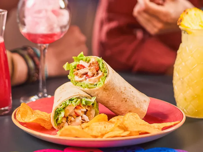 Wrap au poulet coupé en deux avec chips et cocktails colorés au Rio Grande Bar du Disney Hotel Santa Fe
