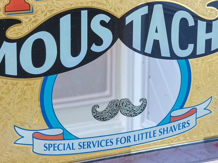 Vitrine "Moustache" avec moustache dessinée, boutique de coiffure Dapper Dan’s Hair Cuts, Main Street, Disneyland Paris
