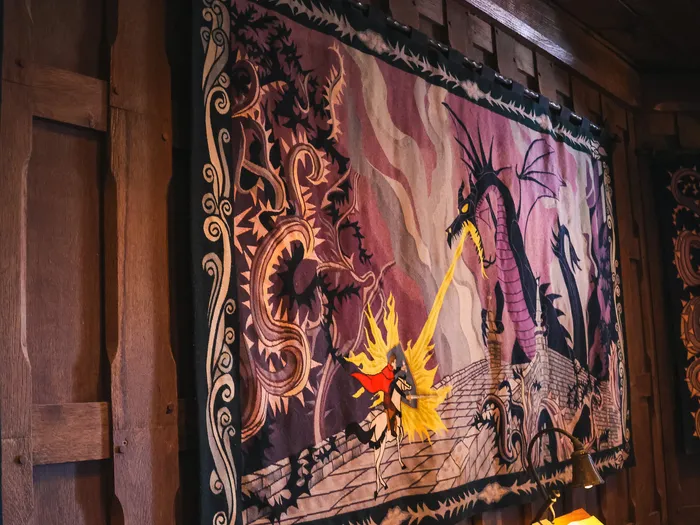 Grande tapisserie du prince affrontant le dragon Maléfique, accrochée dans la Galerie de la Belle au Bois Dormant.