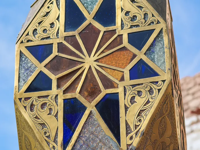 Chased brass lantern with blue and amber stained glass in front of Les Trésors de Schéhérazade, in Adventureland at Disneyland Paris