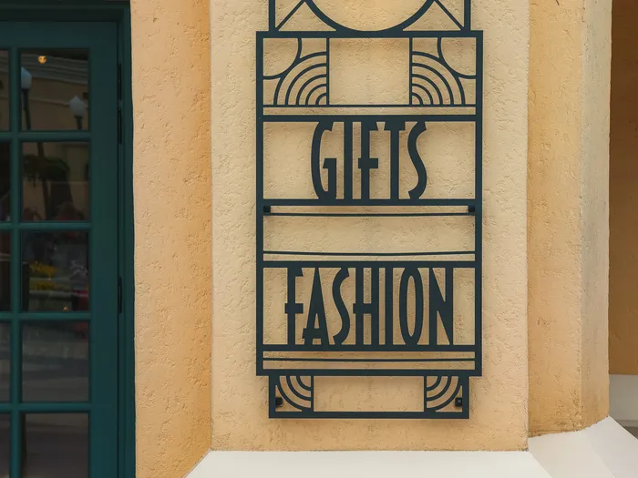 Panneau Art déco "Gifts Fashion" près de l’entrée vitrée du Walt Disney Studios Store