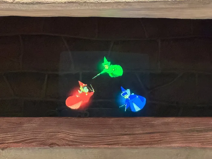 Projection of the three good fairies (red, green, blue) in La Confiserie des Trois Fées at Disneyland Paris.