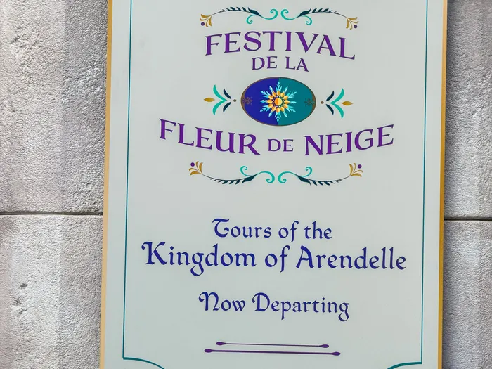 Bannière suspendue Proclamation Festival de la Fleur de Neige sur un mur de pierre, décor de Frozen Ever After.