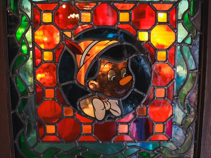 Stained-glass window showing Pinocchio in La Bottega di Geppetto at Disneyland Paris.