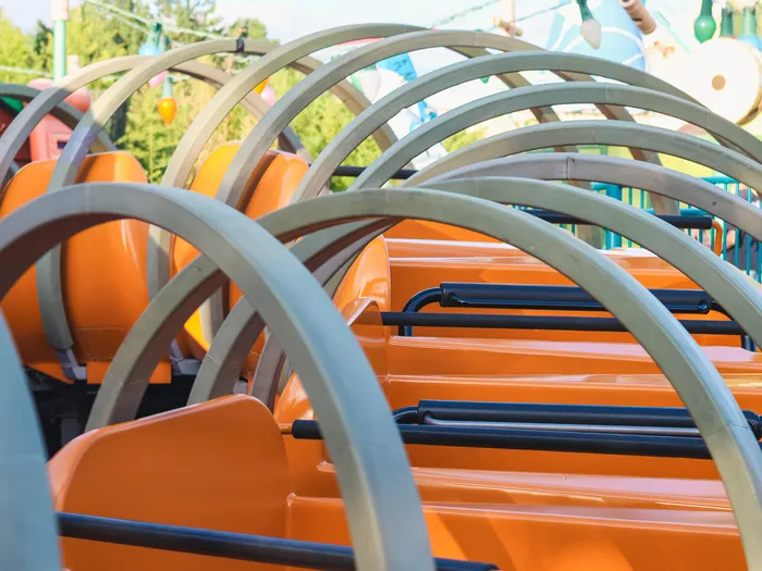 Train orange de Slinky Dog Zigzag Spin cerclé d’anneaux gris imitant le ressort, attraction de Toy Story Playland