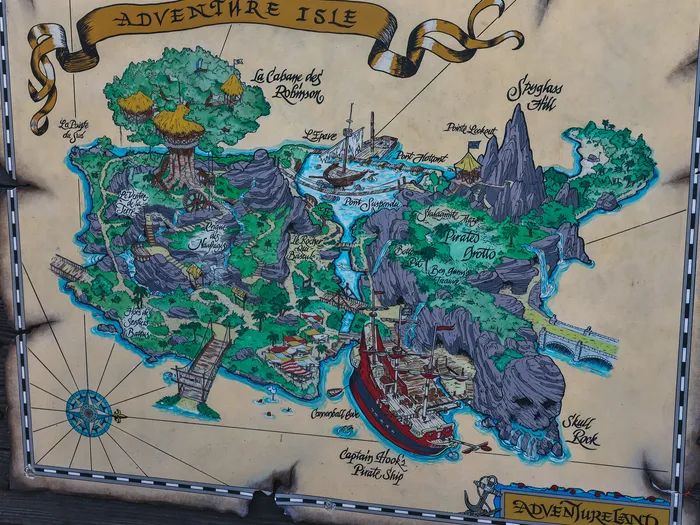 Panneau peint représentant la carte d’Adventure Isle avec ses îles, grottes et bateau pirate, à Adventureland