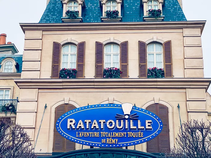 Façade parisienne et enseigne bleue de l’attraction Ratatouille, L’Aventure Totalement Toquée de Rémy