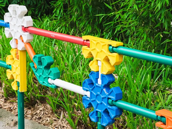 Barrière faite de pièces de jeu de construction géantes colorées bordant une allée de Worlds of Pixar.