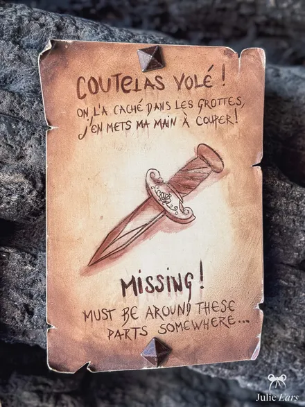 "Stolen cutlass!" notice nailed to a rock on Adventure Isle at Disneyland Paris, with a drawing of a pointed blade with a floral guard