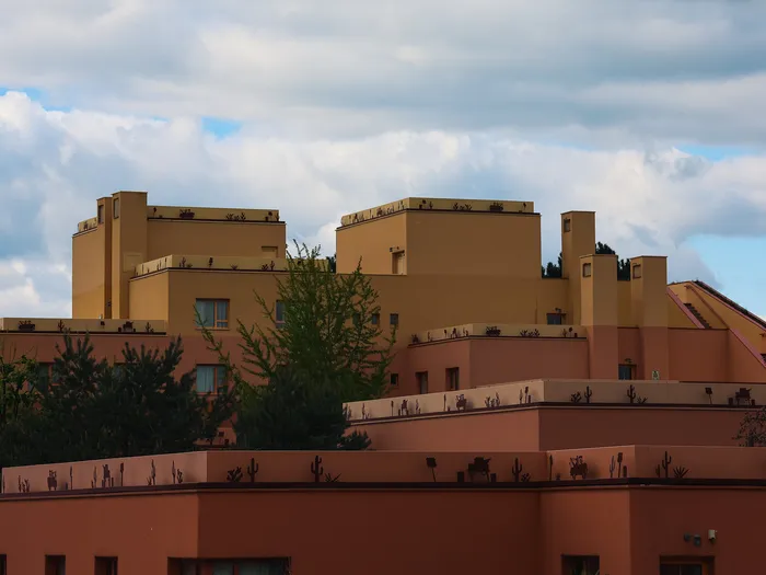 Bâtiments ocre et terracotta du Disney Hotel Santa Fe sous un ciel nuageux