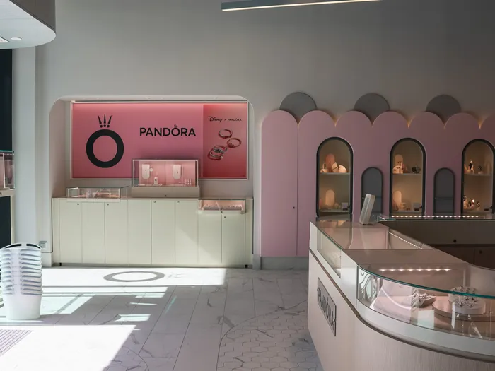 Pandora corner and jewellery cases in the Disney Glamour shop, pink wall with arched alcoves