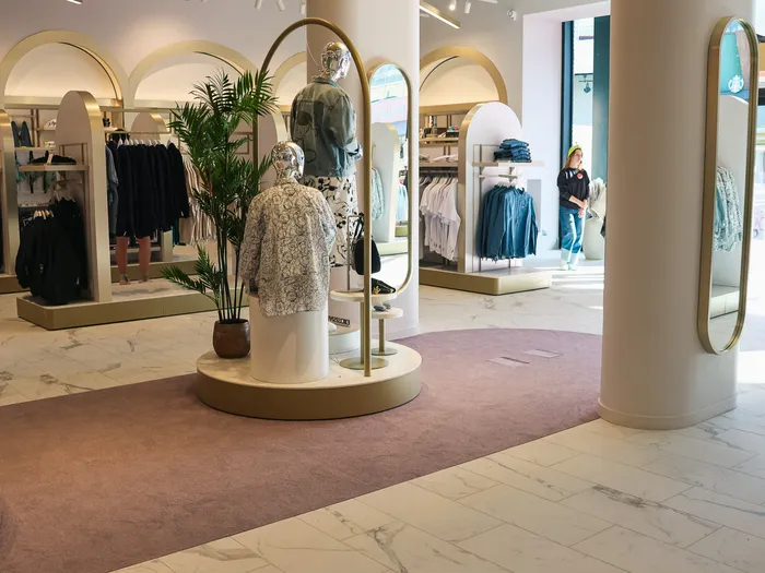 Intérieur lumineux de Disney Style avec arches, mannequin sur podium et sol en marbre