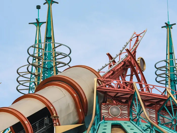 Sommet d’Hyperspace Mountain de jour : canon métallique et flèches turquoise et rouges se détachant sur le ciel bleu.