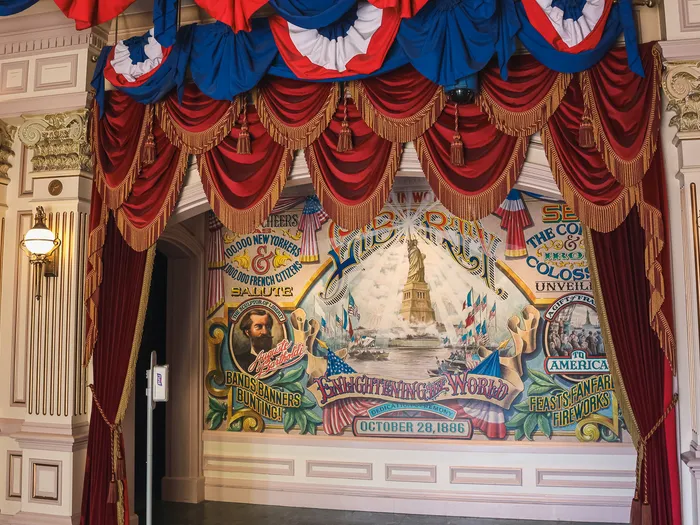 Fresque de la Statue de la Liberté encadrée de drapés bleu-blanc-rouge dans le passage Liberty Arcade.