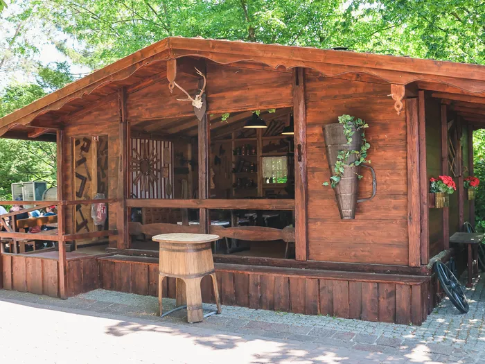 Chalet en bois avec terrasse et bois de cerf en décor, entouré d’arbres, à Europa-Park